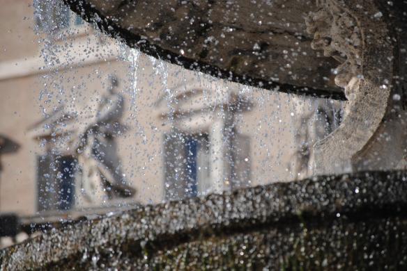 A view of a statue through a fountain at St Peters Basillica, Vatican